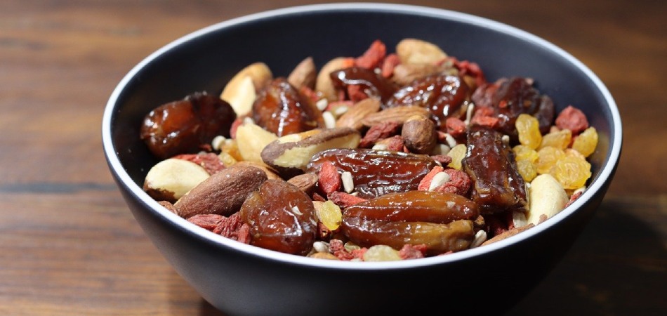 Gezonde paranotenmix: ideaal voor zoete en hartige gerechten Gezonde mix van paranoten, dadels en rozijnen in zwarte kom