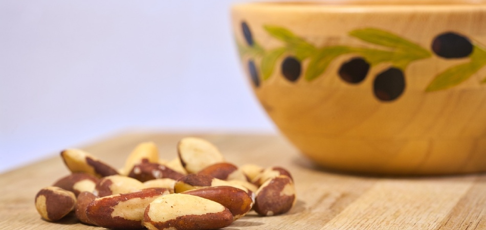 Paranoten zijn gezond en veelzijdig in gebruik Paranoten op houten plank naast decoratieve houten schaal
