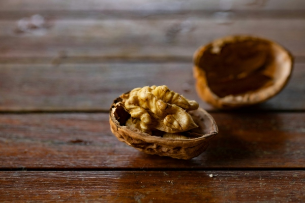 Stap voor stap walnoten roosteren 2 walnoothelften op een houten ondergrond