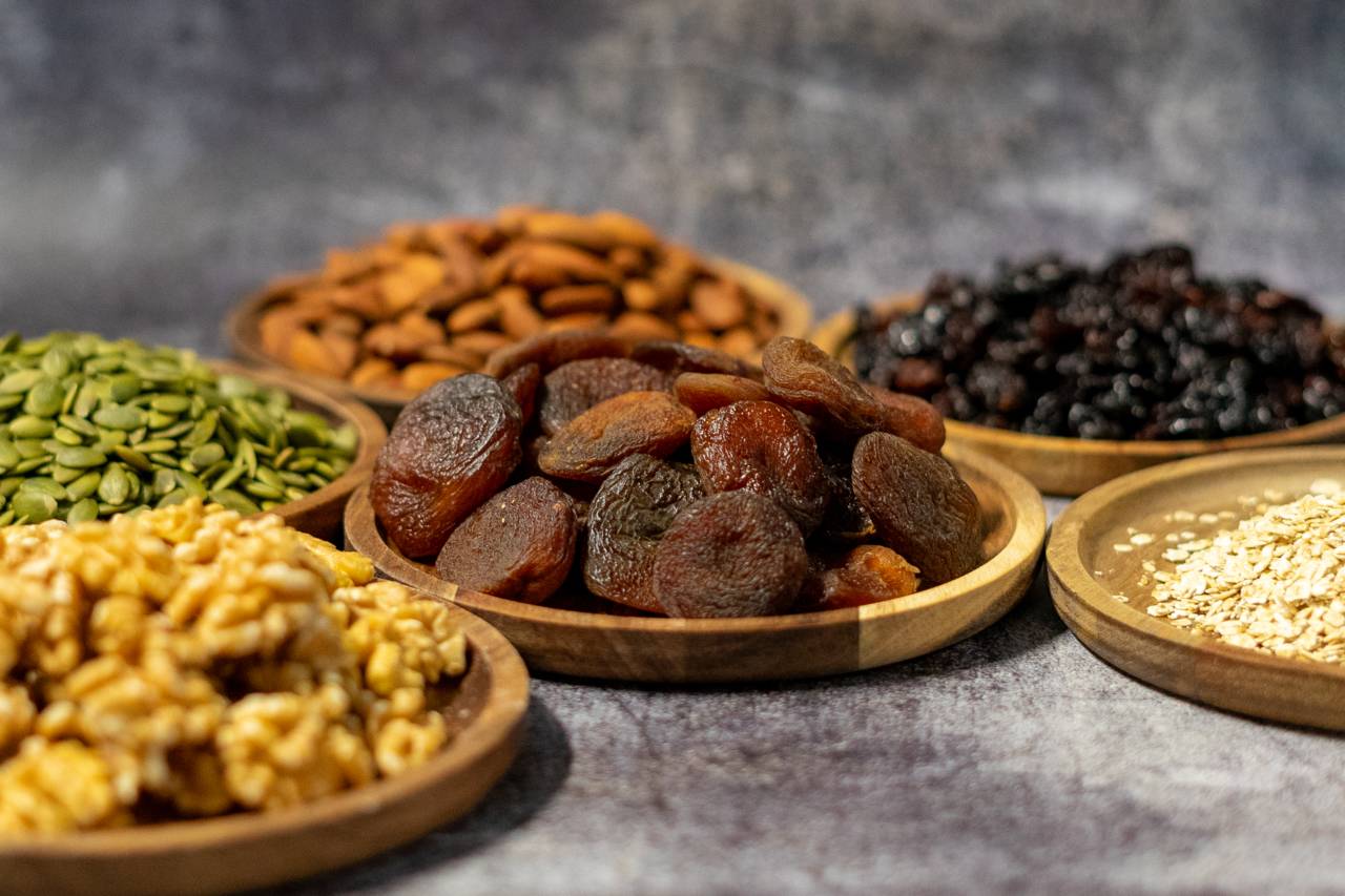 Verschillende noten, granen en pitten en gedroogd fruit op houten plateau's